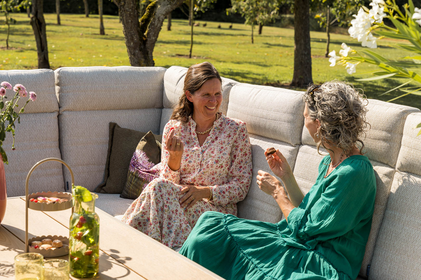 Menschen entspannen in einem ländlichen Garten mit Loungeset