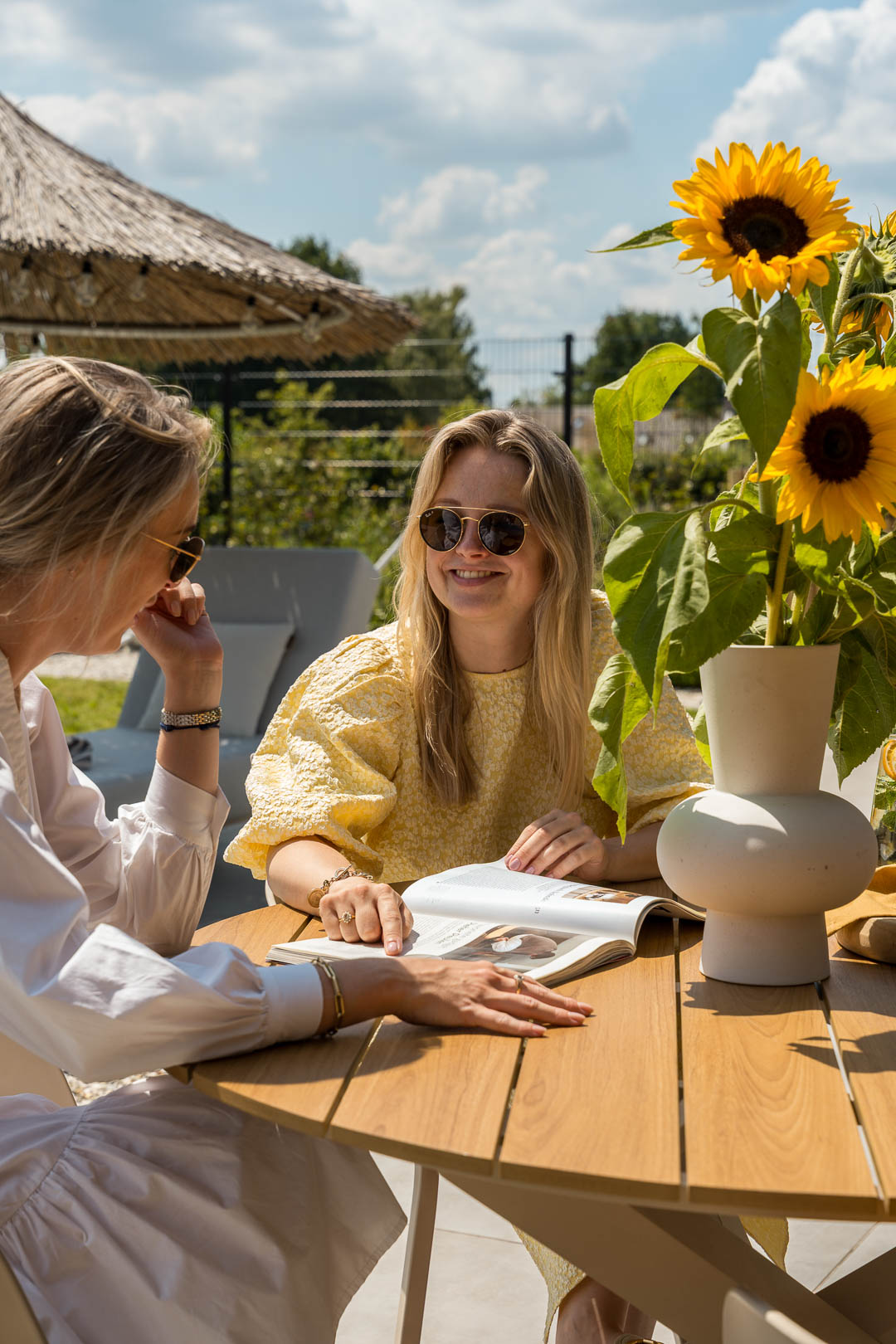 Menschen sitzen gemeinsam an einem Gartentisch in einem modernen Garten